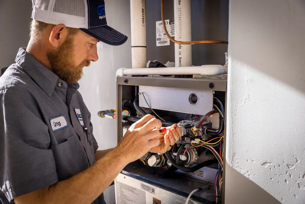 Goettl’s High Desert Mechanical technician working on wall-mounted HVAC system – Prescott Valley AZ